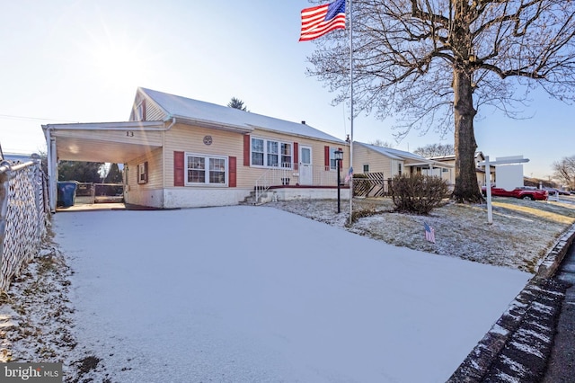 snow covered back of property with a carport