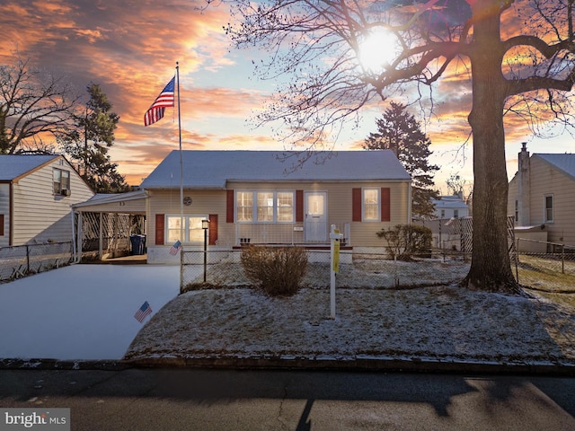 view of front of property with concrete driveway, a carport, and a fenced front yard