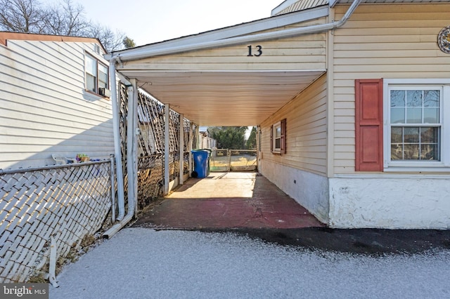 view of home's exterior featuring an attached carport and fence