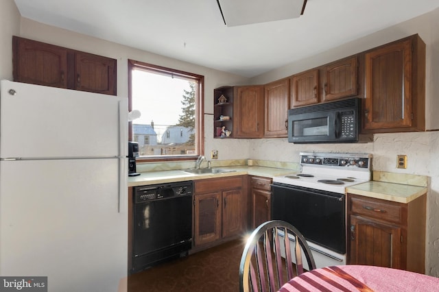 kitchen with a sink, dark floors, light countertops, black appliances, and open shelves