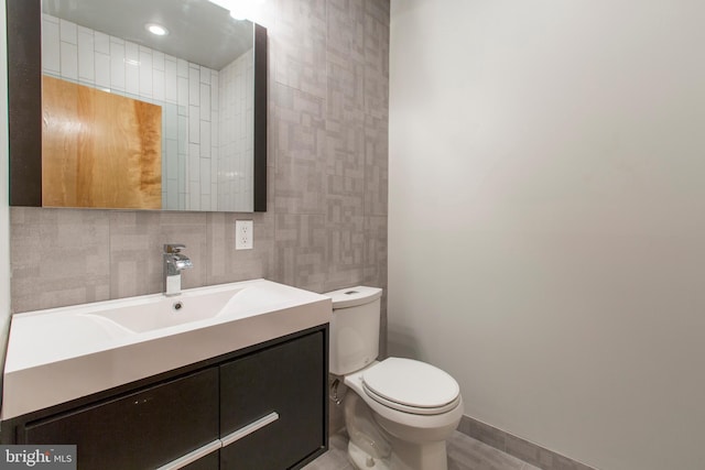 bathroom featuring vanity, tasteful backsplash, and toilet