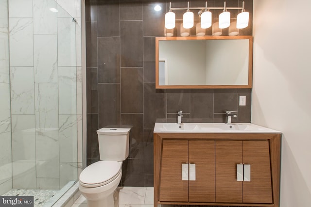 bathroom featuring vanity, decorative backsplash, toilet, tiled shower, and tile walls