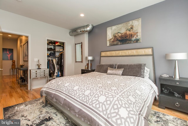 bedroom featuring light hardwood / wood-style flooring, a spacious closet, and a closet