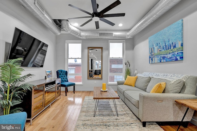 living room with light hardwood / wood-style floors and ceiling fan