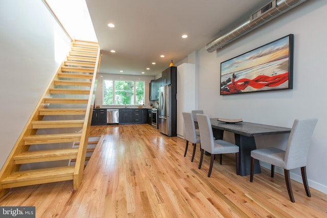 dining space with sink and light hardwood / wood-style flooring