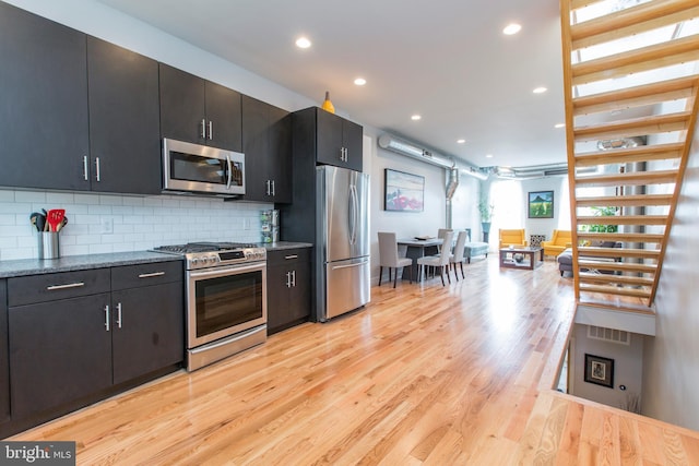 kitchen featuring decorative backsplash, appliances with stainless steel finishes, and light hardwood / wood-style flooring