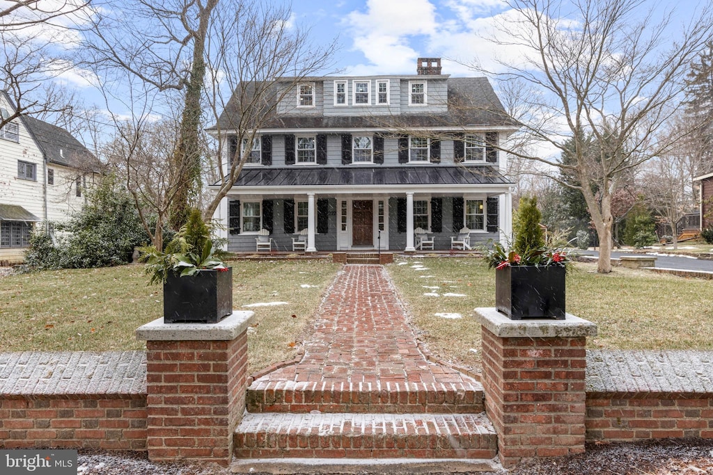 view of front of house featuring covered porch and a front lawn