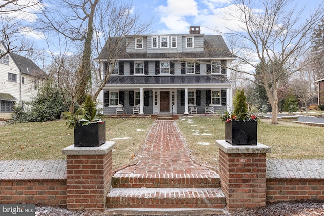 view of front of house featuring covered porch and a front lawn