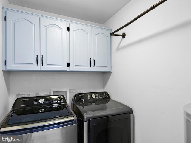 laundry room with cabinets and washing machine and clothes dryer