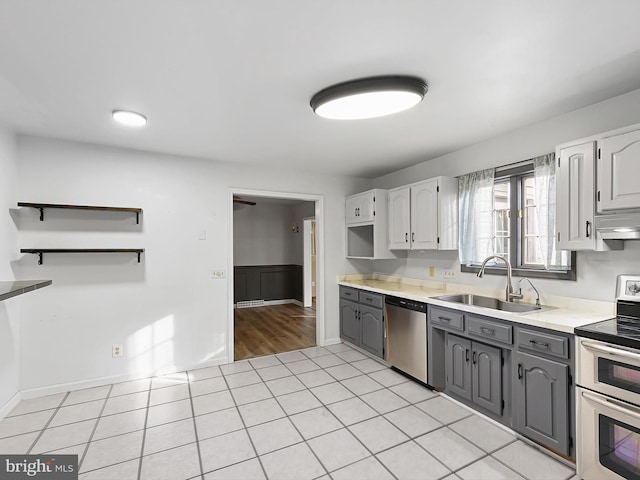 kitchen with sink, stainless steel appliances, gray cabinetry, and light tile patterned floors