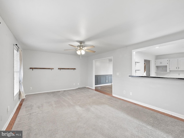 unfurnished living room with ceiling fan and carpet floors