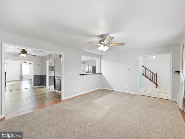 unfurnished living room featuring ceiling fan and carpet flooring