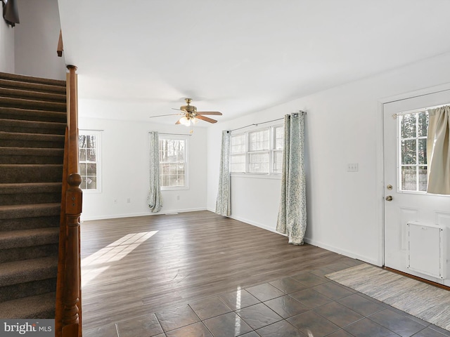 unfurnished living room featuring dark hardwood / wood-style flooring and ceiling fan