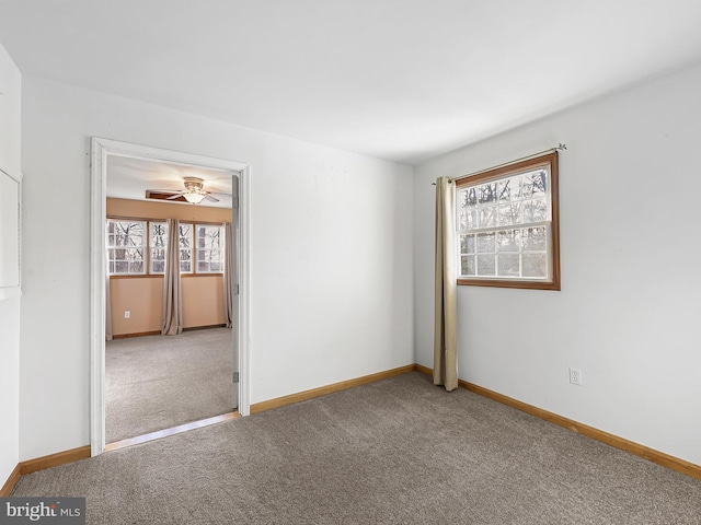 empty room featuring carpet floors and ceiling fan