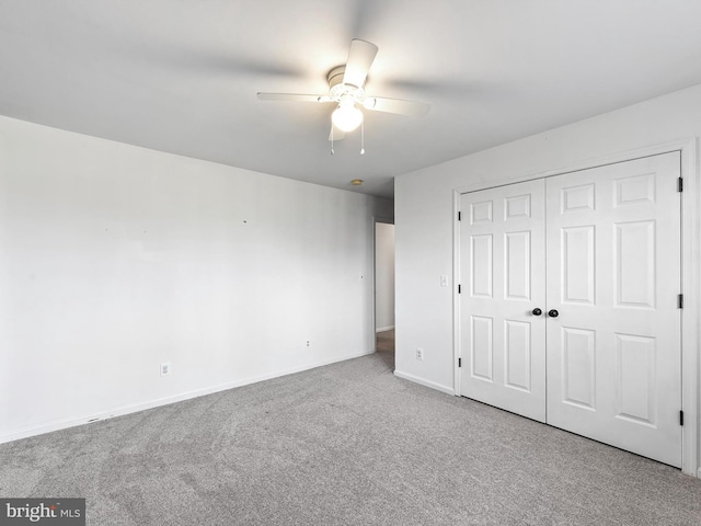 unfurnished bedroom with ceiling fan, a closet, and light carpet