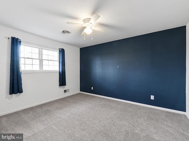 unfurnished room with ceiling fan and carpet flooring