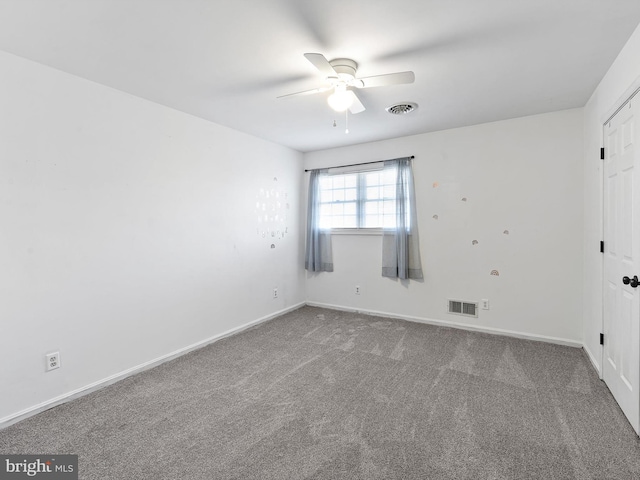 carpeted spare room featuring ceiling fan