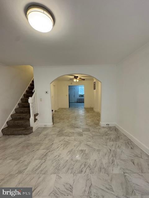 empty room featuring ceiling fan and crown molding