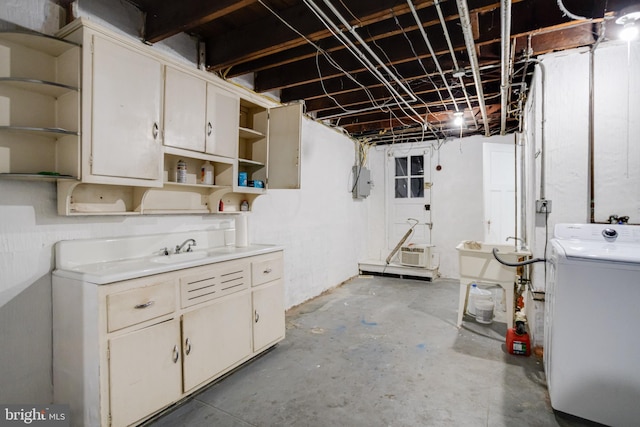 basement featuring sink, electric panel, and washer / clothes dryer