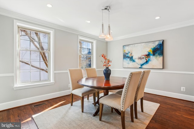 dining space with dark wood-type flooring and ornamental molding