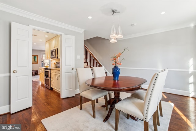 dining area featuring dark wood-type flooring and ornamental molding