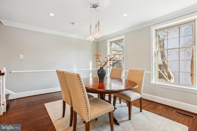 dining space featuring ornamental molding and dark hardwood / wood-style flooring