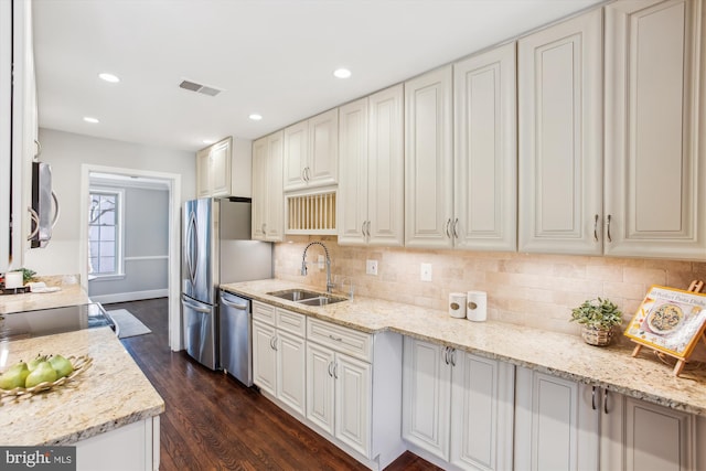 kitchen featuring white cabinetry, sink, light stone counters, and stainless steel appliances