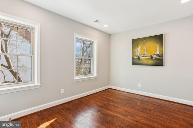 unfurnished room with hardwood / wood-style flooring and a wealth of natural light