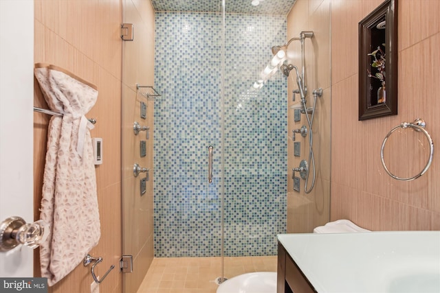 bathroom with tile patterned floors, an enclosed shower, tile walls, and vanity