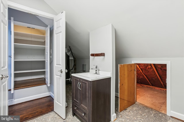 bathroom featuring vaulted ceiling and vanity