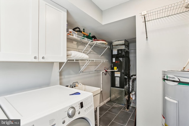 washroom with washer / dryer, heating unit, cabinets, electric water heater, and dark tile patterned floors