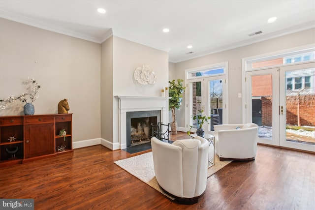 living room featuring dark hardwood / wood-style floors, ornamental molding, and french doors