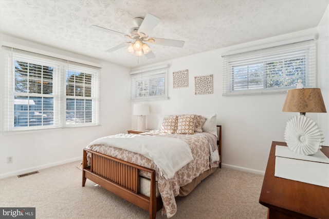 bedroom featuring ceiling fan, carpet floors, and a textured ceiling