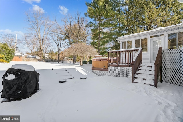 yard covered in snow featuring a wooden deck and a hot tub