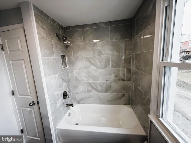 bathroom with tiled shower / bath and a healthy amount of sunlight