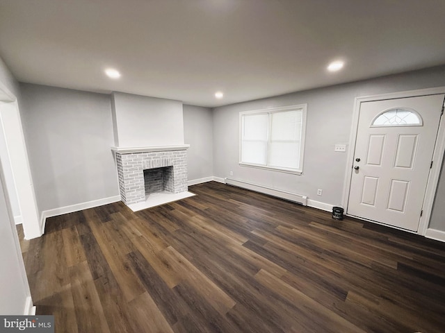 unfurnished living room featuring a baseboard radiator, dark hardwood / wood-style flooring, and a fireplace