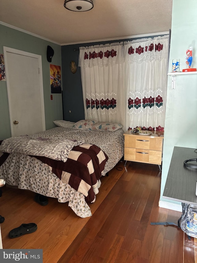 bedroom with crown molding and dark hardwood / wood-style flooring