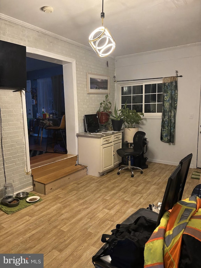 office with ornamental molding, brick wall, and light hardwood / wood-style flooring