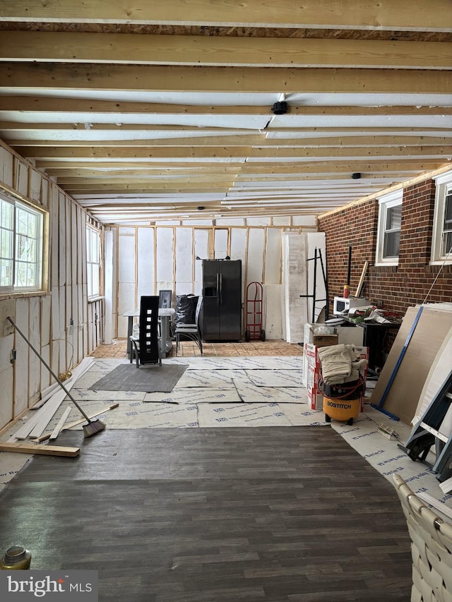 interior space with wood-type flooring and brick wall