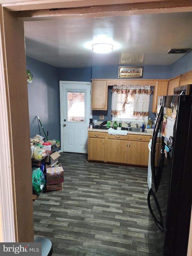 kitchen featuring black refrigerator and dark hardwood / wood-style floors