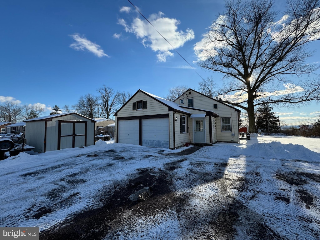 view of front of house with a garage and a shed