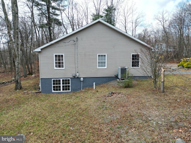 view of home's exterior with cooling unit and a yard