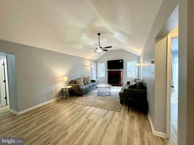 living room with light hardwood / wood-style floors, ceiling fan, and lofted ceiling