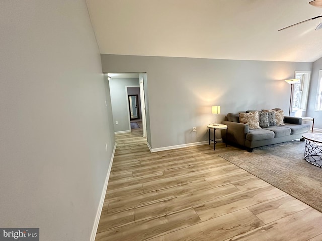 living room featuring light wood-type flooring, vaulted ceiling, and ceiling fan