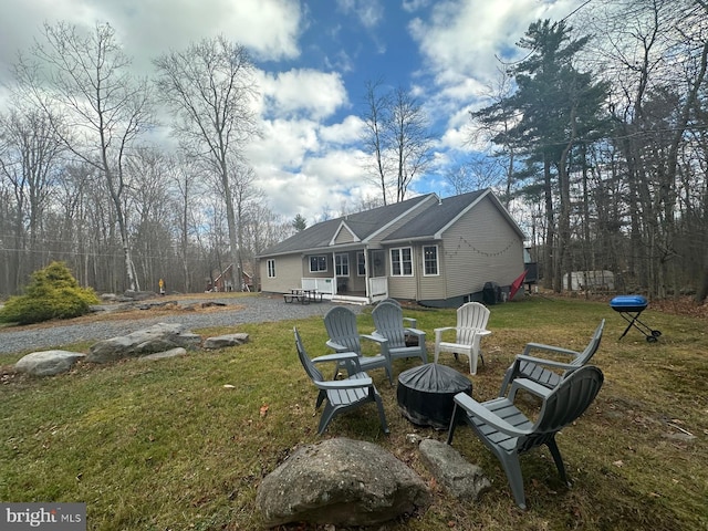 back of house featuring a patio area, a yard, and an outdoor fire pit