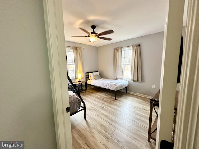 bedroom with multiple windows, light wood-type flooring, and ceiling fan