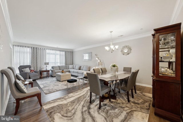 dining area featuring a chandelier, hardwood / wood-style flooring, and crown molding