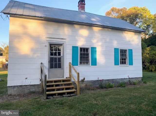 back of house featuring a lawn