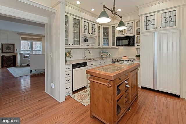 kitchen featuring paneled refrigerator, dishwashing machine, sink, pendant lighting, and white cabinets