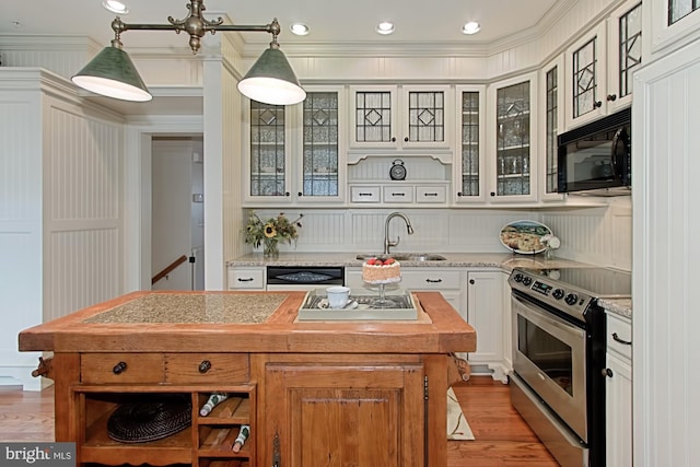 kitchen with sink, black appliances, decorative light fixtures, a center island, and white cabinetry